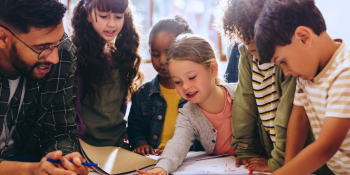 group of students with teacher engaging at a table