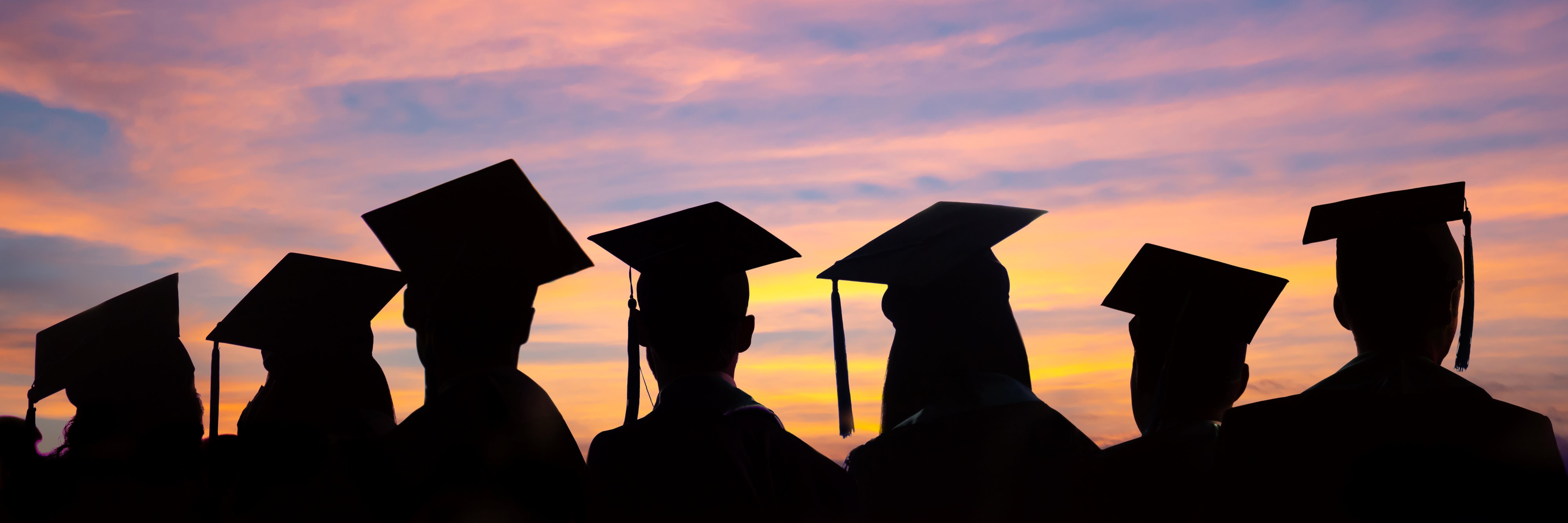 stock-photo-silhouettes-of-students-with-graduate-caps-in-a-row-on-sunset-background-graduation-ceremony-at-1648595998.jpg