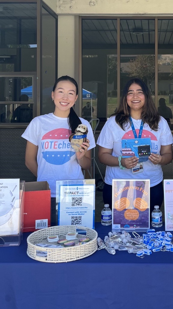 Two interns at a table promoting high school voter registration