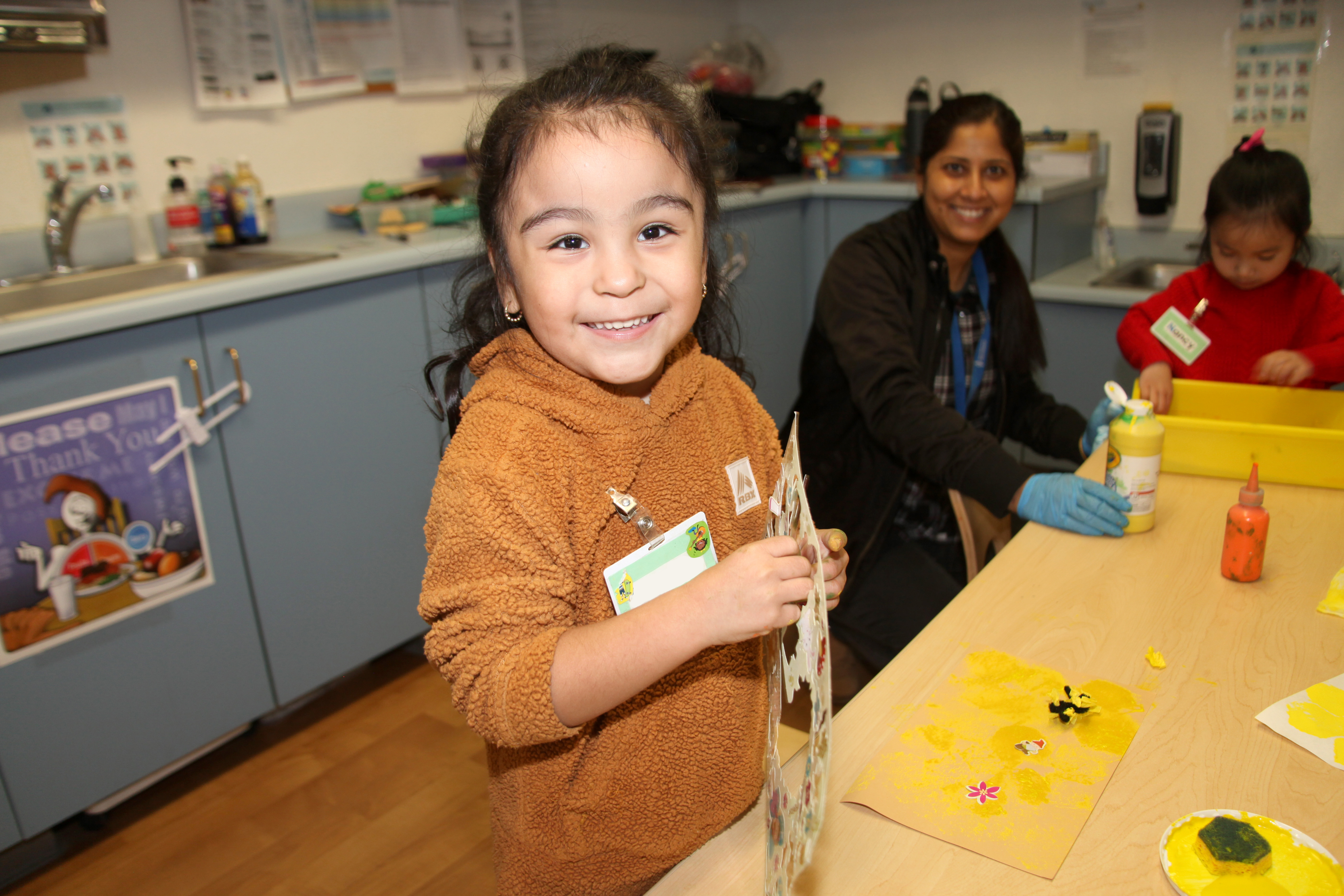 A child smiling while creating an art project 