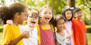 six happy elementary aged kids outside having fun
