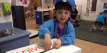 Smiling kid put a ballot in a box
