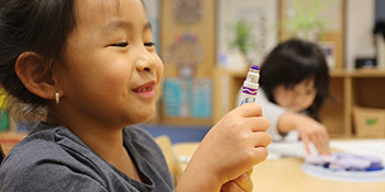 A kid holding a crayon