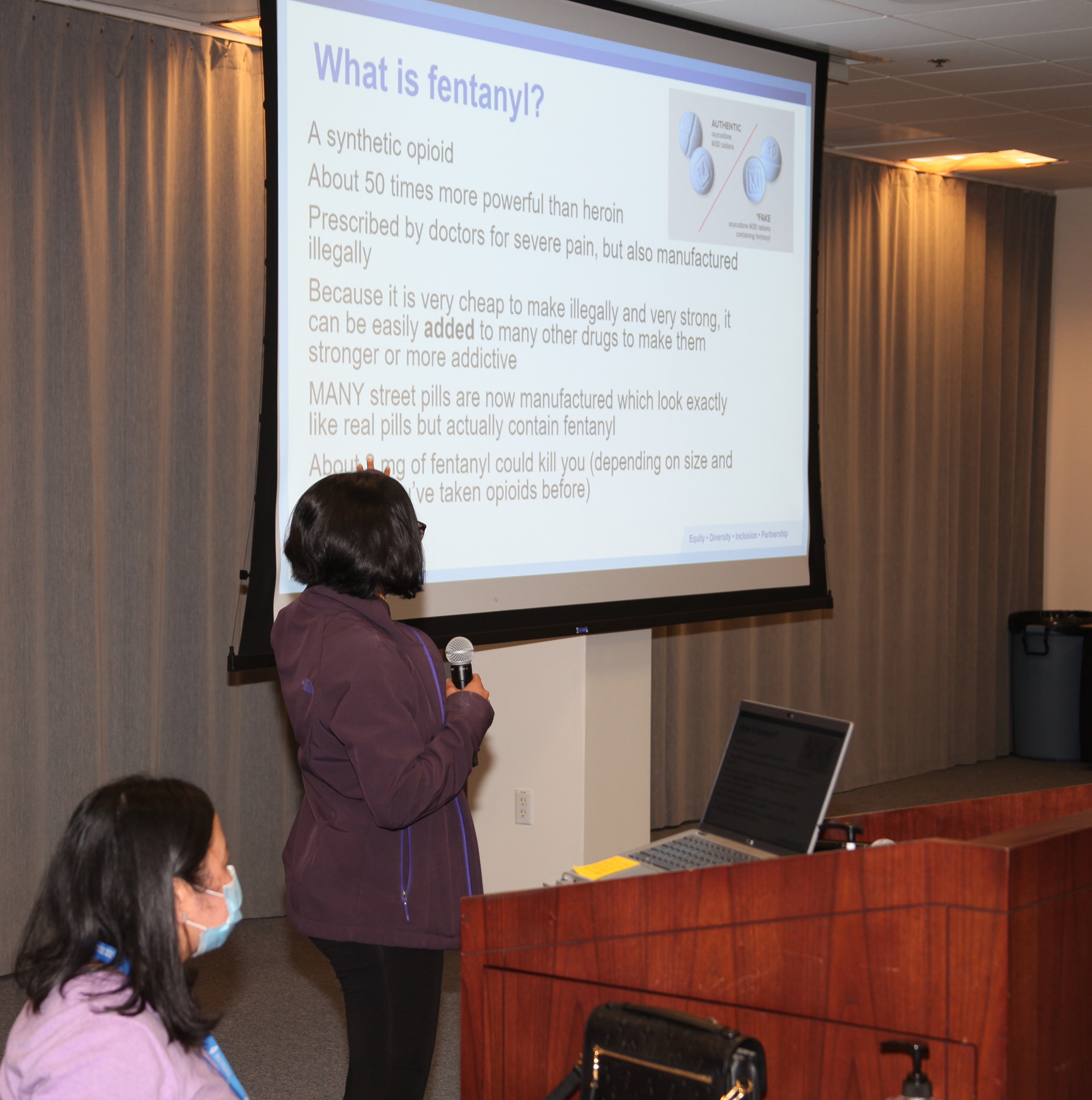 Narcan Training session with speaker and a presentation slide on a projector sharing information related to what fentanyl is